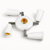 Modern ceiling light fixture with four white lampshades on a white background