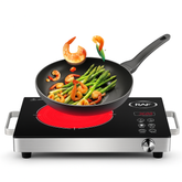 Induction cooktop with a frying pan containing shrimp and asparagus on a white background