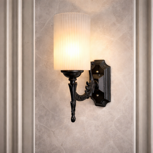 Black decorative wall sconce with ribbed shade on marble wall