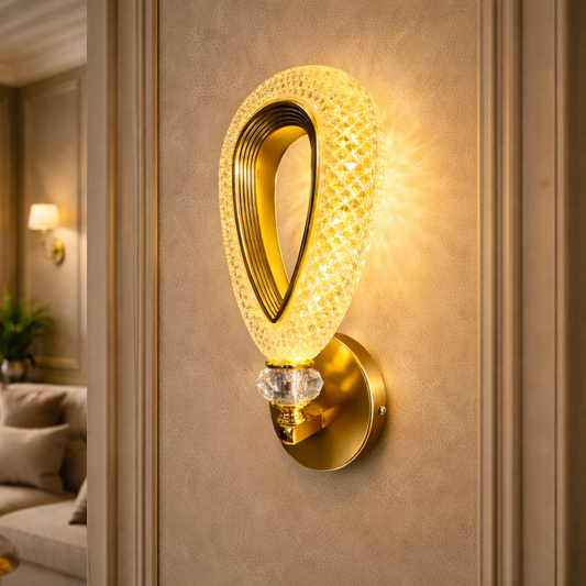 Modern gold crystal LED wall light glowing warmly on textured wall