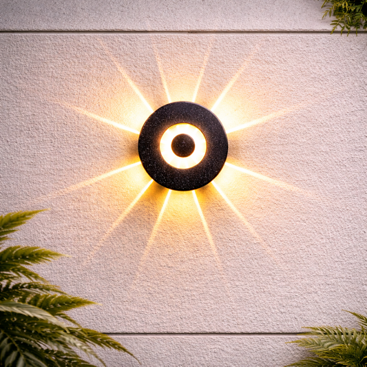 Modern outdoor wall light fixture on a textured wall with plants at the base.