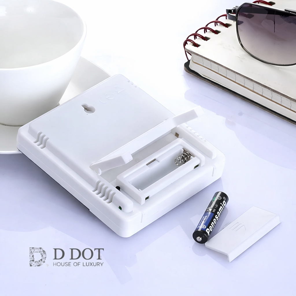 White battery charger with a battery on a light surface, featuring the D Dot brand.