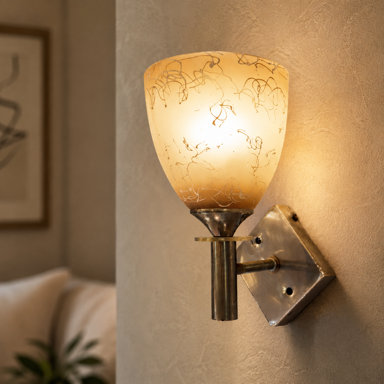 Wall-mounted lamp with decorative glass shade on a textured wall.