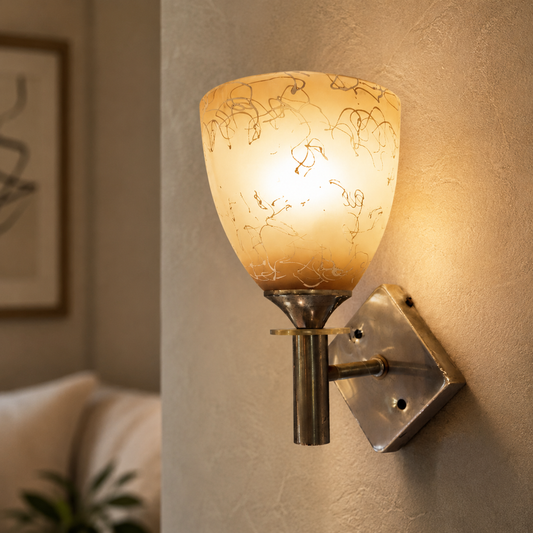 Wall-mounted lamp with decorative glass shade on a textured wall.