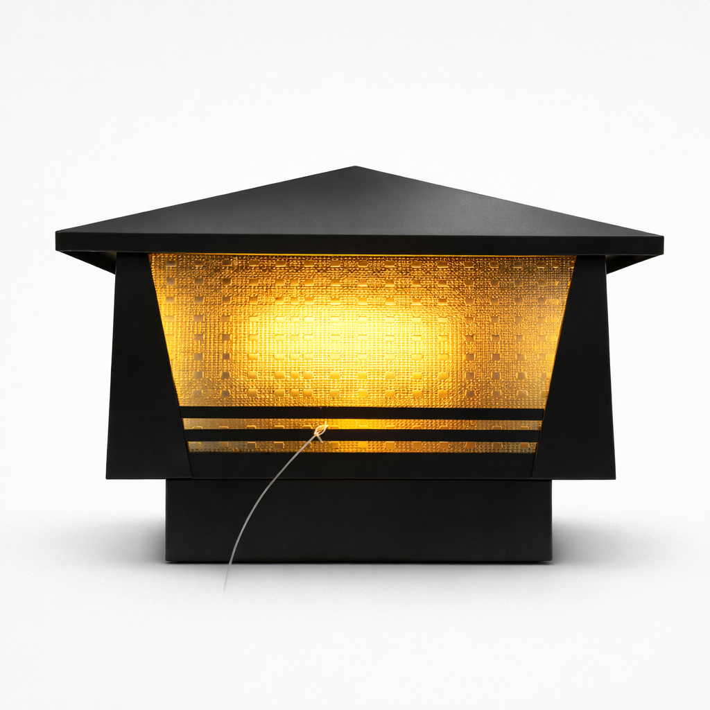 Modern outdoor light fixture with a black hexagonal design and warm yellow light on a white background