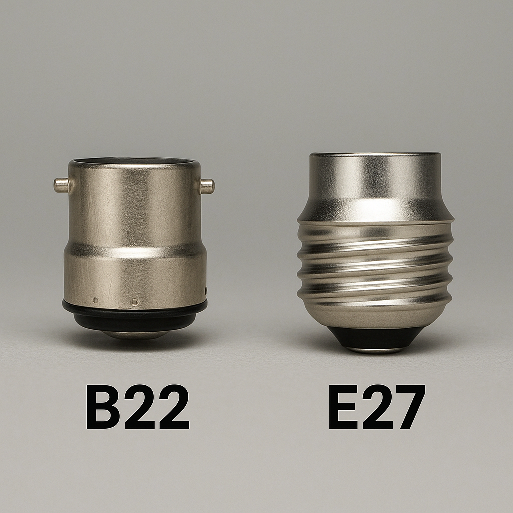 Two metallic light bulb sockets labeled B22 and E27 on a gray background