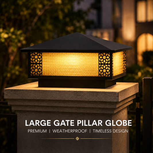Large gate pillar globe light on a post with decorative cut-out design, surrounded by blurred outdoor setting.