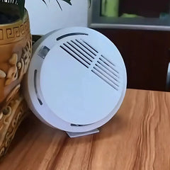 "Compact Smoke Detector for Home or Office Safety placed on a wooden surface"