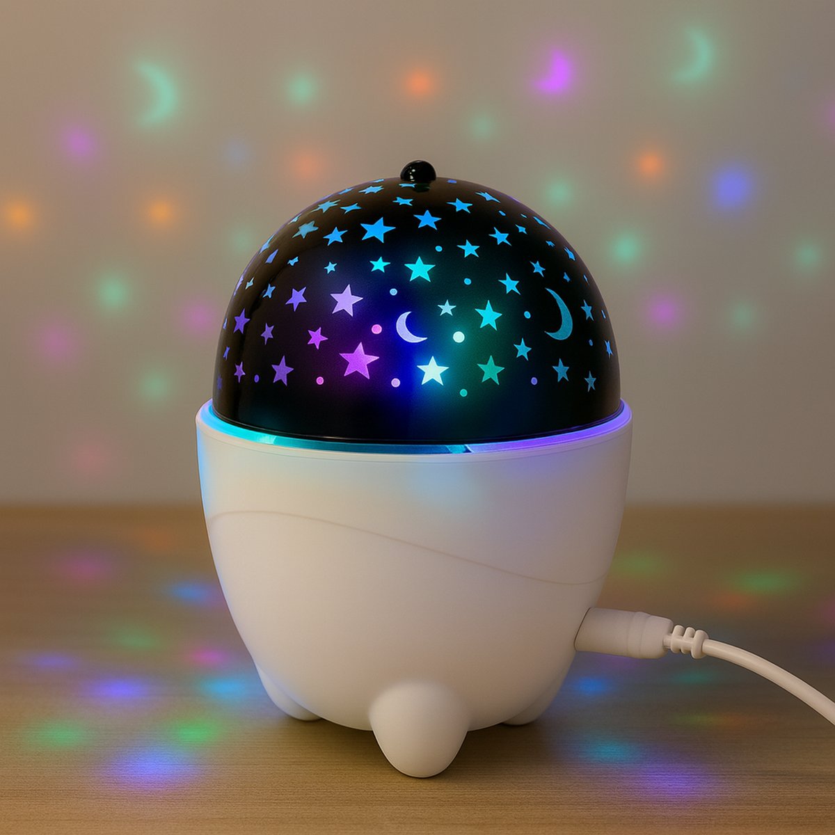 Star and moon projector lamp glowing with colorful LED lights on wooden table in cozy room