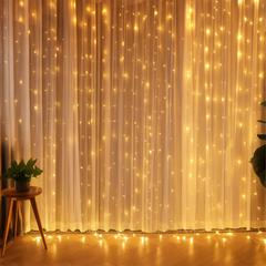 Decorative string lights on a curtain with a wooden stool and plants in the foreground.